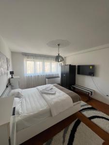 ein Schlafzimmer mit einem großen weißen Bett und einem TV in der Unterkunft Moj dom in Gornji Milanovac