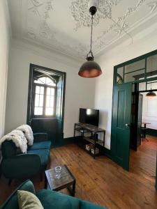 a living room with a blue couch and a green door at Jugendstil Villa - 2 min zum Meer in Figueira da Foz