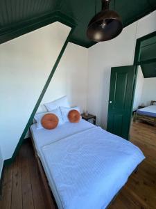 a bedroom with a bed with white sheets and a green door at Jugendstil Villa - 2 min zum Meer in Figueira da Foz