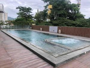 a large swimming pool with a wooden deck at Sundance Residences, your home at the heart of the city! in Cebu City