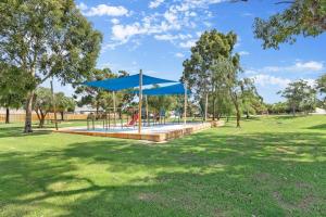 a picnic area with a blue canopy in a park at Quiet & Comfy in Hamilton Hill