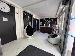 a bathroom with a clock on the wall and two toilets at Modern's Hotel in Paris