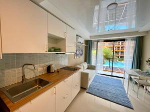 a kitchen with a sink and a large window at 777 Beach condo - family condo near Mai Khao beach in Ban Mai Salae