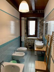 ein Bad mit 2 Waschbecken, einem WC und einem Fenster in der Unterkunft Il sogno del pescatore in Scilla
