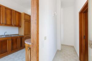a kitchen with wooden cabinets and a counter top at Villa Tina Maria by BarbarHouse in San Pietro in Bevagna