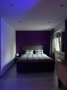 a bedroom with purple walls and a bed with pillows at Apartman Maksimir with free parking in Zagreb