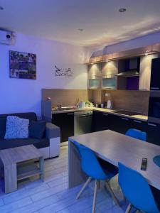 cocina y sala de estar con mesa y sillas azules en Apartman Maksimir with free parking en Zagreb
