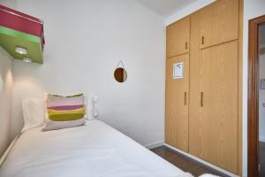 a small bedroom with a bed and a cabinet at Apartment Arquímedes in Barcelona