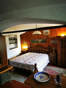 Boves的住宿－La Quiete nel verde，一间卧室配有一张床和一张桌子,上面有盘子