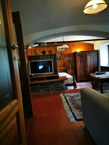 uma sala de estar com uma cama e uma televisão em La Quiete nel verde em Boves