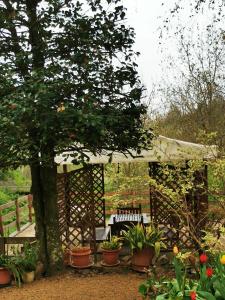 a wooden pergola with a bench in a garden at La Quiete nel verde in Boves