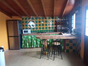 a kitchen with a counter and stools in a room at Casona Eladio in San José de Caideros