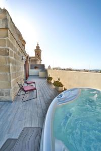 a swimming pool on a patio with a building at Quaint Boutique Hotel Nadur in Nadur