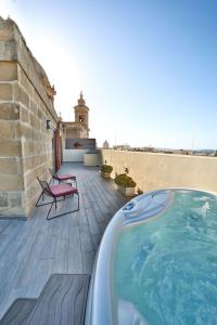 einen Pool auf einer Terrasse mit einem Gebäude in der Unterkunft Quaint Boutique Hotel Nadur in Nadur