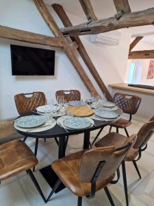 a dining room with a table and chairs and a television at appartement hyper-centre Laurène in La Flèche