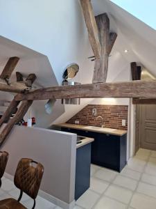 a kitchen with wooden beams on the ceiling and a sink at appartement hyper-centre Laurène in La Flèche