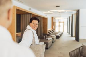 a man standing in a waiting room with a bag at Hotel Weisseespitze in Kaunertal