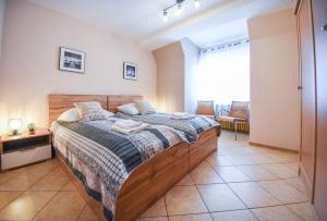um quarto com uma cama grande e uma cabeceira em madeira em Apartamenty Bryza- Zeromskiego 5/27 em Świnoujście