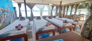 three beds in a room with a view of the ocean at Morning Walsh Resort in El Nido