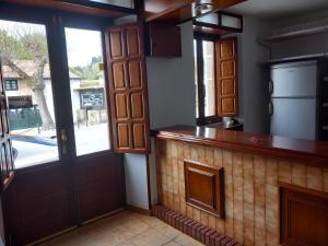 een keuken met een aanrecht en een deur met een raam bij Pensión Baires in O Coto