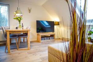een woonkamer met een tafel en een televisie bij Smart Resorts Haus Opal Ferienwohnung 404 in Winterberg