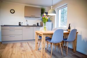 cocina con mesa de madera y sillas azules en Smart Resorts Haus Opal Ferienwohnung 404, en Winterberg