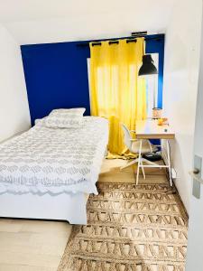 a bedroom with a bed and a desk with a yellow curtain at Private rooms in a Tiny home 4 min drive to Airport CDG ,1 private bathroom ideal for families and friends in Roissy-en-France