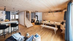 a living room with a couch and a table and a kitchen at Gähwindehof Mountain Ranch Resort in Oberstaufen