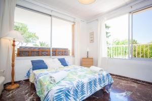 ein Schlafzimmer mit einem Bett und einem großen Fenster in der Unterkunft Bell-Punt in Port d'Alcúdia