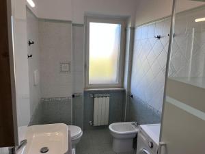 La salle de bains est pourvue d'un lavabo, de toilettes et d'une fenêtre. dans l'établissement Titina's house - Peace and nature in Fiumicino, à Fiumicino