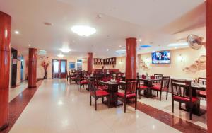 a dining room with tables and chairs in a restaurant at Silver Mounts Hotel in Phnom Penh