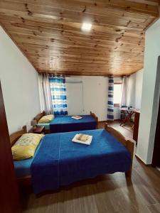 two beds in a room with wooden ceilings at Old Town - Guest House in Stari Bar