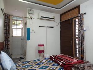 een kamer met een bed, een raam en een deur bij Saar Homestay in Ujjain