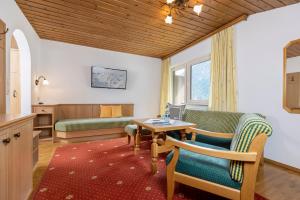 Una sala de estar con dos sillas y una mesa. en Appart & Hotel Garni Villa Knauer, en Mayrhofen