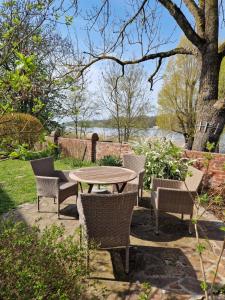 a patio with a table and chairs and a tree at Ferienhaus Vörn-Diek in Hohnstorf