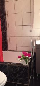 un jarrón de flores rosas en un estante del baño en Angel Room 2, en Nea Plagia