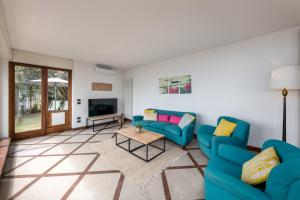 a living room with two blue couches and a table at Villa Lexa by Casa da Suite in Lesa