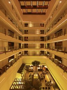 an empty lobby of a building with tables and chairs at Ramee Grand Hotel and Spa, Pune in Pune