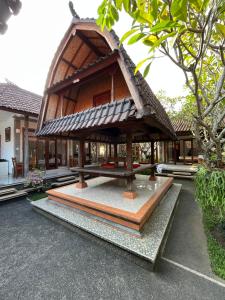 un petit bâtiment avec un toit en haut dans l'établissement Sujana Homestay, à Ubud