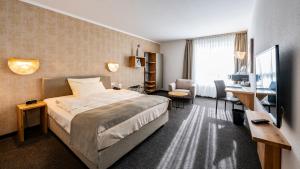 a hotel room with a bed and a desk at Best Western Plus iO Hotel in Eschborn