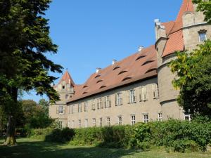 a large brick building with a red roof at Schloss Frankenberg in Weigenheim