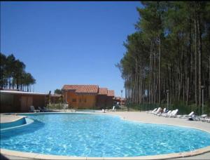 una gran piscina con sillas y un edificio en Chalet*** tout confort à 5 km de la plage, en Bias