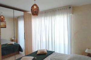 um quarto com uma cama e uma grande janela em T2 CALME + cadre verdoyant em Besse-sur-Issole