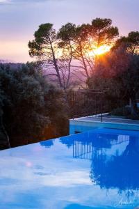 uma piscina com o pôr-do-sol ao fundo em T2 CALME + cadre verdoyant em Besse-sur-Issole