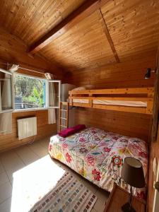 1 dormitorio con 1 cama en una cabaña de madera en Chalet*** tout confort à 5 km de la plage, en Bias