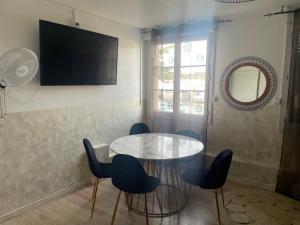 a dining room with a table and chairs and a television at Family Hôtel FUTUROSCOPE in Jaunay-Clan