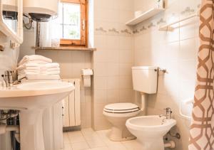 a white bathroom with a toilet and a sink at [Aosta - La Thuile] - Condominio Rolland in La Thuile