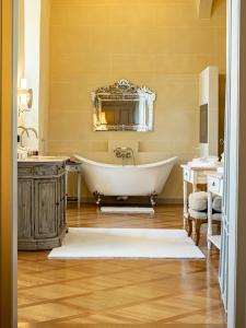 a bathroom with a tub and a mirror at Schloss Frankenberg in Weigenheim