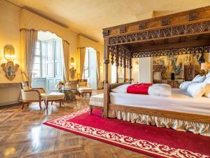 a bedroom with a large bed and a red rug at Schloss Frankenberg in Weigenheim