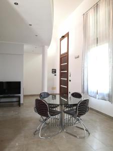 a dining room with a glass table and chairs at Domus Open Space in San Donato di Lecce